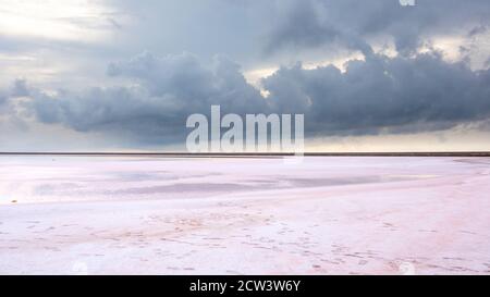 Salt pink lake surface under gray purple high layered epic clouds on sky. Dramatic natural skyline on spa healthcare natural resort Stock Photo