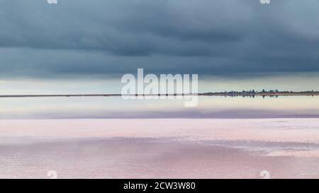 Salt pink lake reflective mirror water surface with vivid blue dramatic layered epic clouds on sky. Panoramic spa healthcare natural resort in Ukraine Stock Photo