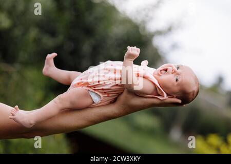 Supporting Hands. Father holding his 14 days old baby girl on his arms Stock Photo