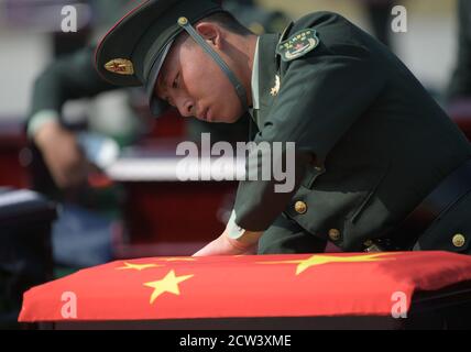 Shenyang, China. 27th Sep, 2020. An honor guard covers a casket containing the remains of the Chinese People's Volunteers (CPV) martyr with national flag at the Taoxian international airport in Shenyang, northeast China's Liaoning Province, Sept. 27, 2020. The remains of 117 Chinese soldiers killed in the 1950-53 Korean War were returned to China on Sunday from the Republic of Korea (ROK). Credit: Xinhua/Alamy Live News Stock Photo
