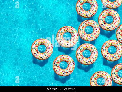 Large group of inflatable candy doughnut buoys swim in the swimming pool view from above Stock Photo