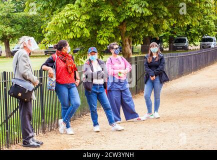 Tourists wearing facemasks / face covering  on a guided walking tour of The Oxfordshire city of Oxford during the covid 19 pandemic Stock Photo