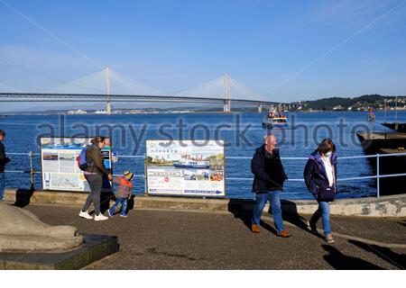 South Queensferry, Scotland, UK. 27th Sep 2020. Fine weather brings out the visitors to South Queensferry. Checking the information board for the Maid of the Forth boat trips. Credit: Craig Brown/Alamy Live News Stock Photo