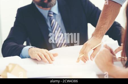 Teamwork. Closeup poto young coworkers crew working with new startup project in modern loft. Pencil holding hands Stock Photo