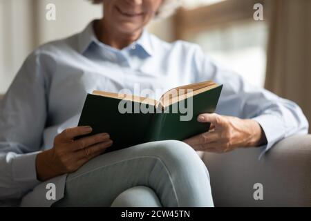 Close up of elderly female holding paper book in hands Stock Photo