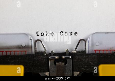 written on old typewriter with text Take Care Stock Photo