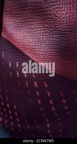 Unusual textured background of dark purple color leather with wrinkled pattern and dotted shadows. Geometric pattern closeup Stock Photo