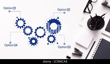 Scheme Of Cogwheels Mechanism Working Over White Office Table Background Stock Photo