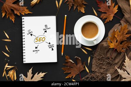 Opened Notebook With Seo Scheme Lying On Black Desk Background Stock Photo