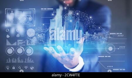 Creative collage of businessman holding virtual smart city hologram and digital interface Stock Photo
