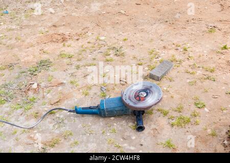 operating angle grinder on the ground. Stock Photo