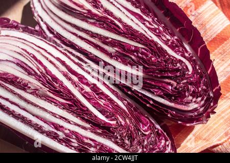 Close-up shot of the colored leaves of a long, early red Treviso radicchio cut in half Stock Photo