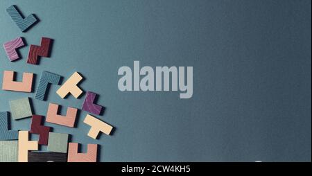 Different colorful shapes wooden puzzle blocks background. Geometric shapes in different colors, top view, copy space Stock Photo