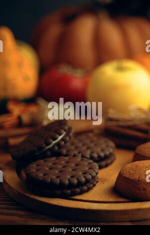 Chocolate chip cookies and cinnamon sticks on a tray. The concept of Thanksgiving, Christmas and Halloween. Baking on a wooden background. Stock Photo