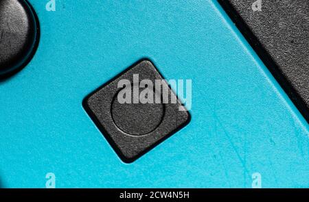 A black square button on a blue hand controller Stock Photo