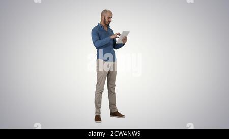 Handsome arabic business man using tablet on gradient background Stock Photo