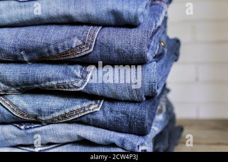 Stack of blue jeans on wooden shelf. Beauty and fashion clothing concept Stock Photo