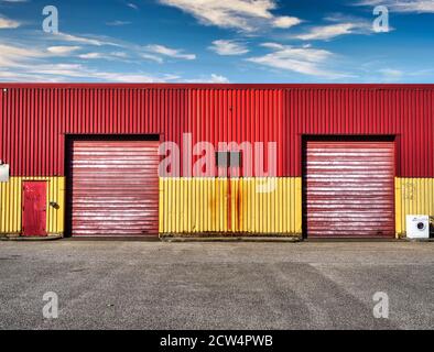 Two closed garage doors on a red and yellow industrial wall Stock Photo