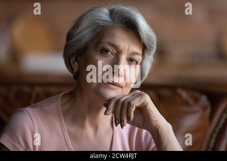 Portrait of mature Caucasian grandmother thinking at home Stock Photo