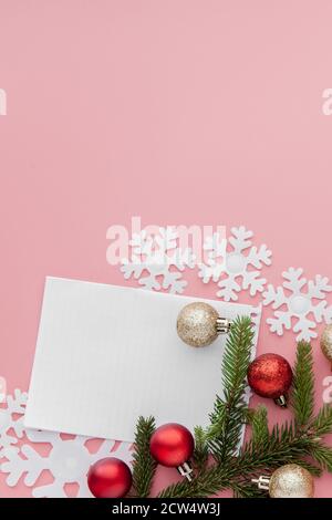 New year concept. Goals list in notepad, gift box and christmas decoration on pink pastel color with copy space Stock Photo