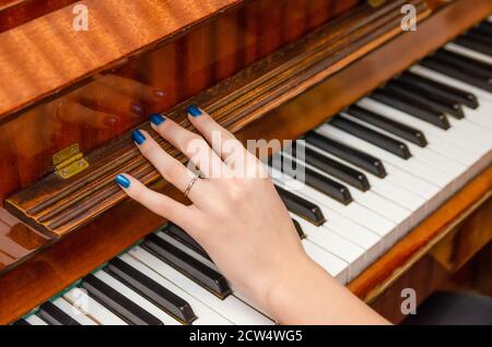 Pianist girl opens the lid of the piano to play on it Stock Photo
