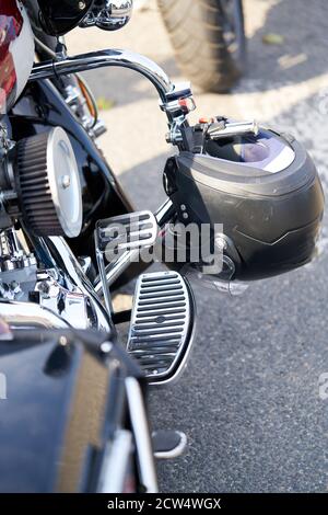 Chrome motorcycle. Stock. Side view of new black motorcycle with chrome details and clothes of motorcyclist lying on it. Chrome details motorcycle ref Stock Photo