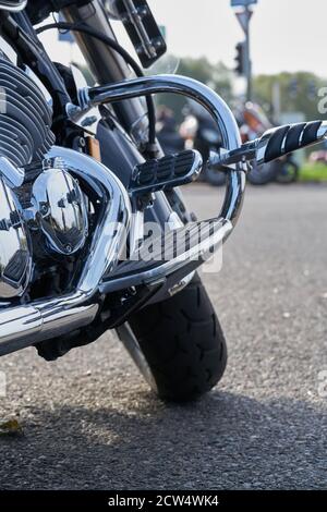 Chrome motorcycle. Stock. Side view of new black motorcycle with chrome details and clothes of motorcyclist lying on it. Chrome details motorcycle ref Stock Photo