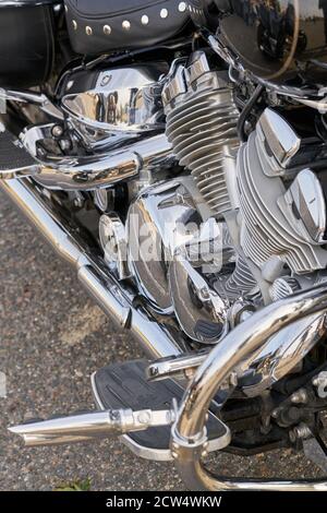 Chrome motorcycle. Stock. Side view of new black motorcycle with chrome details and clothes of motorcyclist lying on it. Chrome details motorcycle ref Stock Photo