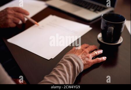Close Up Of Senior Couple At Home Checking Financial Documents On Table Stock Photo