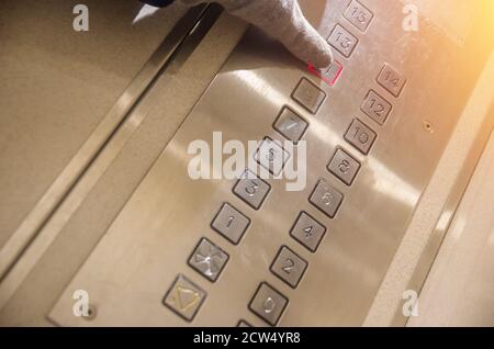 Hand presses the elevator button of the eleventh floor Stock Photo