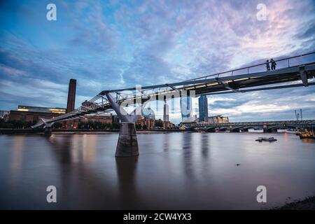 London / UK -  2020.07.18: View of Tate Modern and Thames river behind Millennium Bridge in the eveing with ice blue cloudy sky Stock Photo