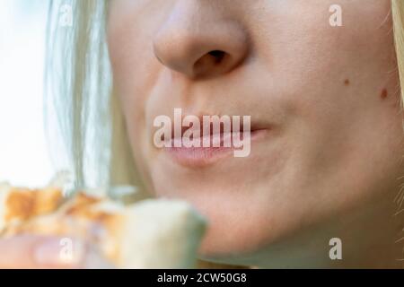 The girl eats shawarma on a sunny day. close-up lips of girl and shawarma. Stock Photo