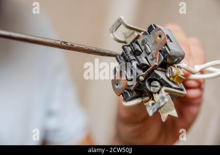 Electrician disassembling wall socket in new building, close up Stock Photo