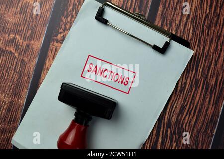 Close up Red Handle Rubber Stamper and text Sanctions isolated on White Background. Stock Photo