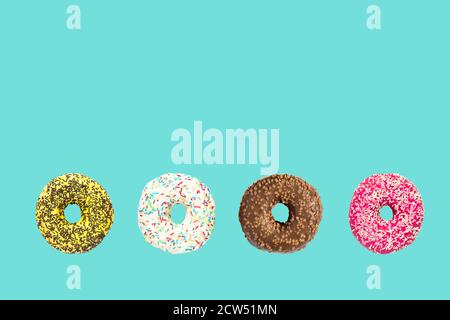 multicolored frosted donuts with colorful sprinkles  and hazels on blue background. Stock Photo