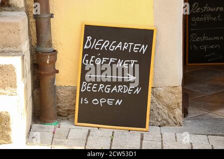Plaque on the street. Text in German and English: Beergarden is open. Stock Photo