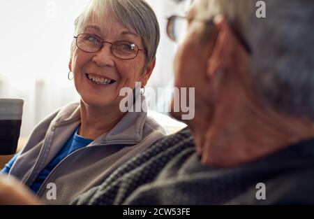 Senior Couple Relaxing And Chatting On Sofa At Home Together Stock Photo