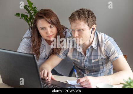 Two programmers, man and woman working from home, remote, home office. Remote work concept - Image Stock Photo