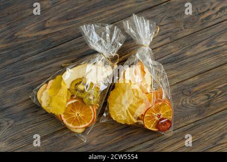set of dried tropical fruits slices on wooden background. Mix of dried pineapple, kiwi, orange, melon and mango tropical fruits. Eco organic healthy f Stock Photo