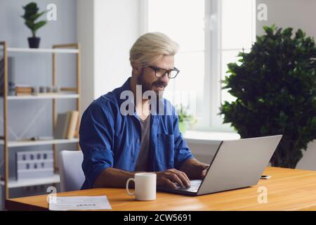 Young man working online on laptop from home Stock Photo