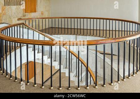 Marble steps of spiral staircase in foyer and circular handrail on the second floor Stock Photo