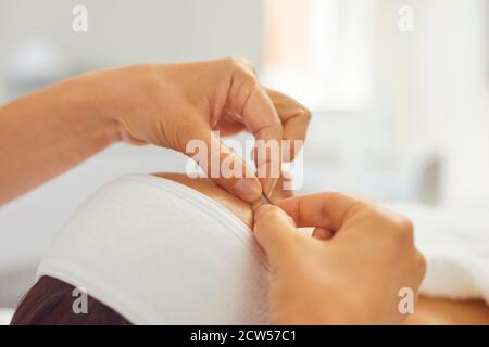 Close-up of cosmetologists hands making lifting massage movements on womans face and eyebrows Stock Photo