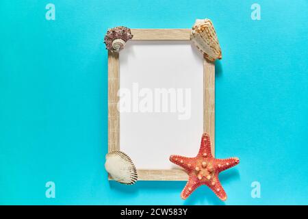 top view of photoframe with seashells and starfish on blue background. Summer vacation concept. Sea flat lay Stock Photo