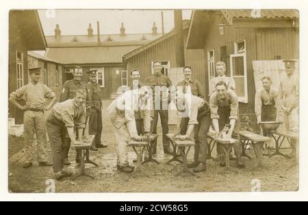 Original WW1 era postcard, during the early part of the war, of cheerful, happy young recruits scrubbing down benches at a training camp, possibly members of the Hampshire Regiment, at Aldershot Camp, Hampshire, U.K. circa 1914 1915 Stock Photo