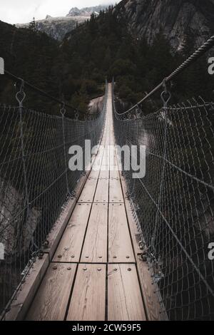 Suspension bridge hanging over river Stock Photo