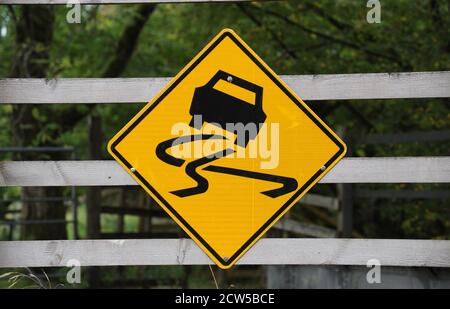 SLIPPERY ROAD WARNING SIGN RE CARS WINTER FROST SKID RISK WET ETC UK Stock Photo