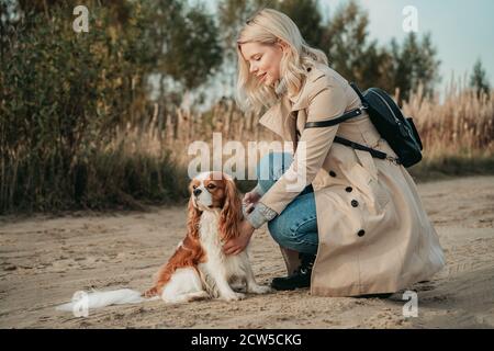 Travel with dog. Young woman walk with her cocker spaniel, backpack on her shoulder Stock Photo