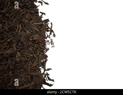 Dried black tea leaves on a white background. Space for text. Stock Photo