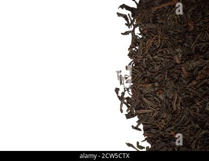 Dried black tea leaves on a white background. Space for text. Stock Photo