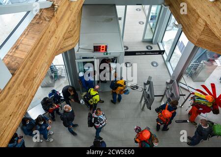 View from above of backpackers waiting for a cabin inside Pointe Helbronner station of Skyway Monte Bianco cable car, Courmayeur, Aosta Valley, Italy Stock Photo
